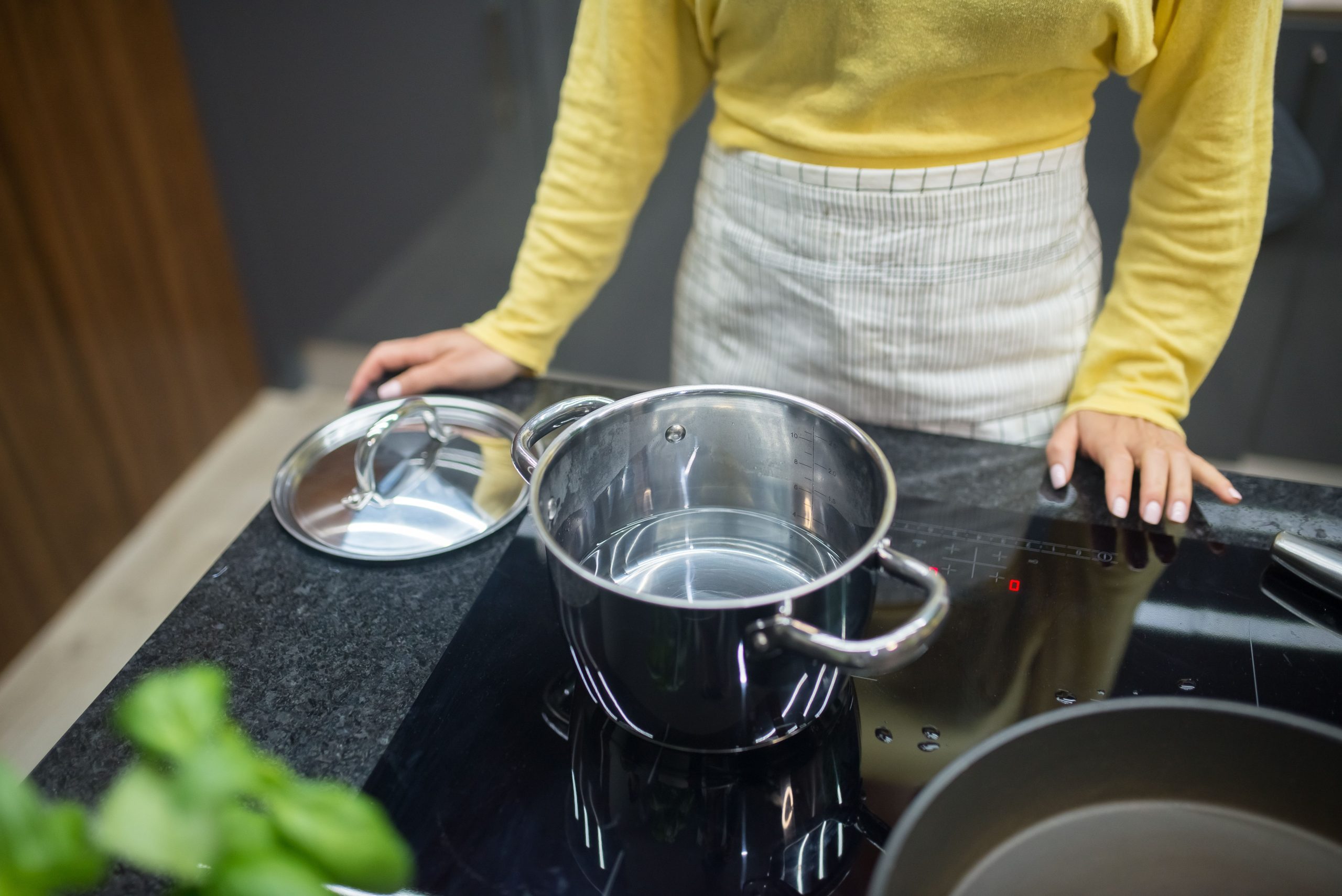 Femme cuisinant avec casserole sur plaque induction