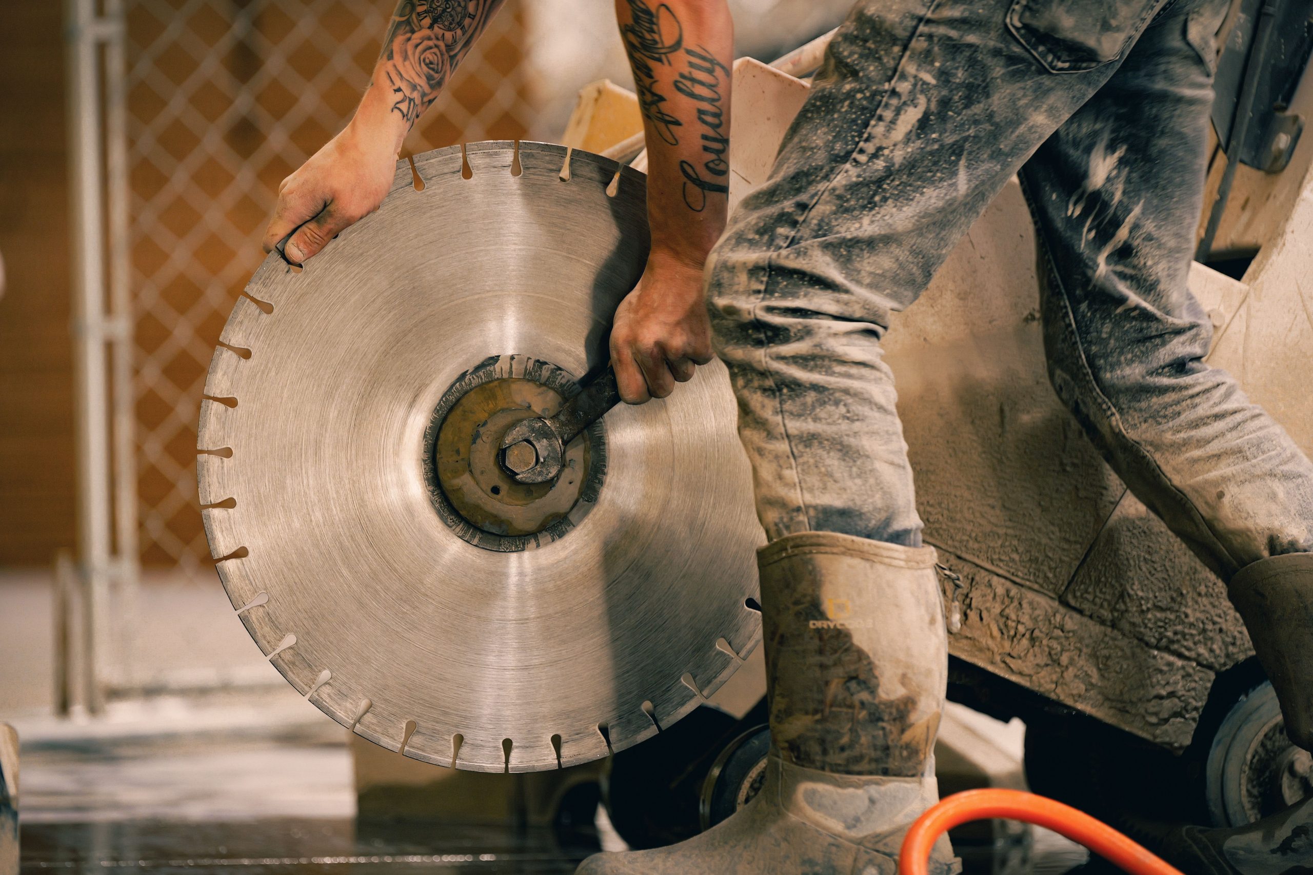 Ouvrier utilisant scie diamantée avec precision