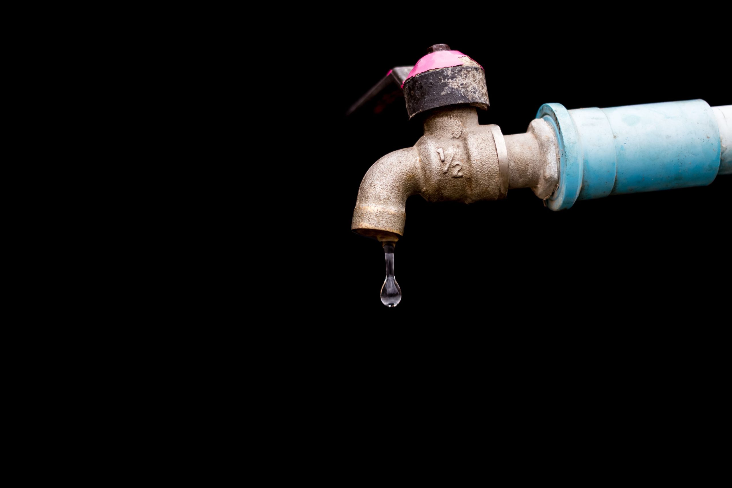 Robinet métallique avec goutte d'eau isolée