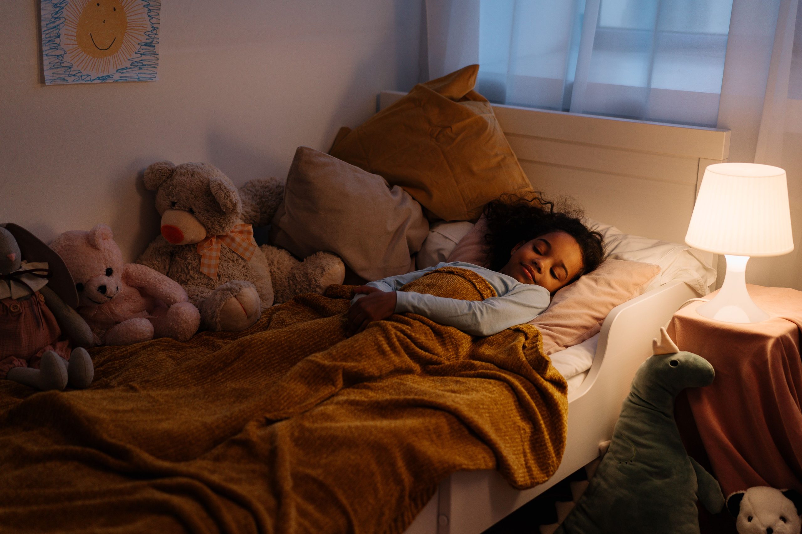 Jeune fille endormie entourée de peluches douces
