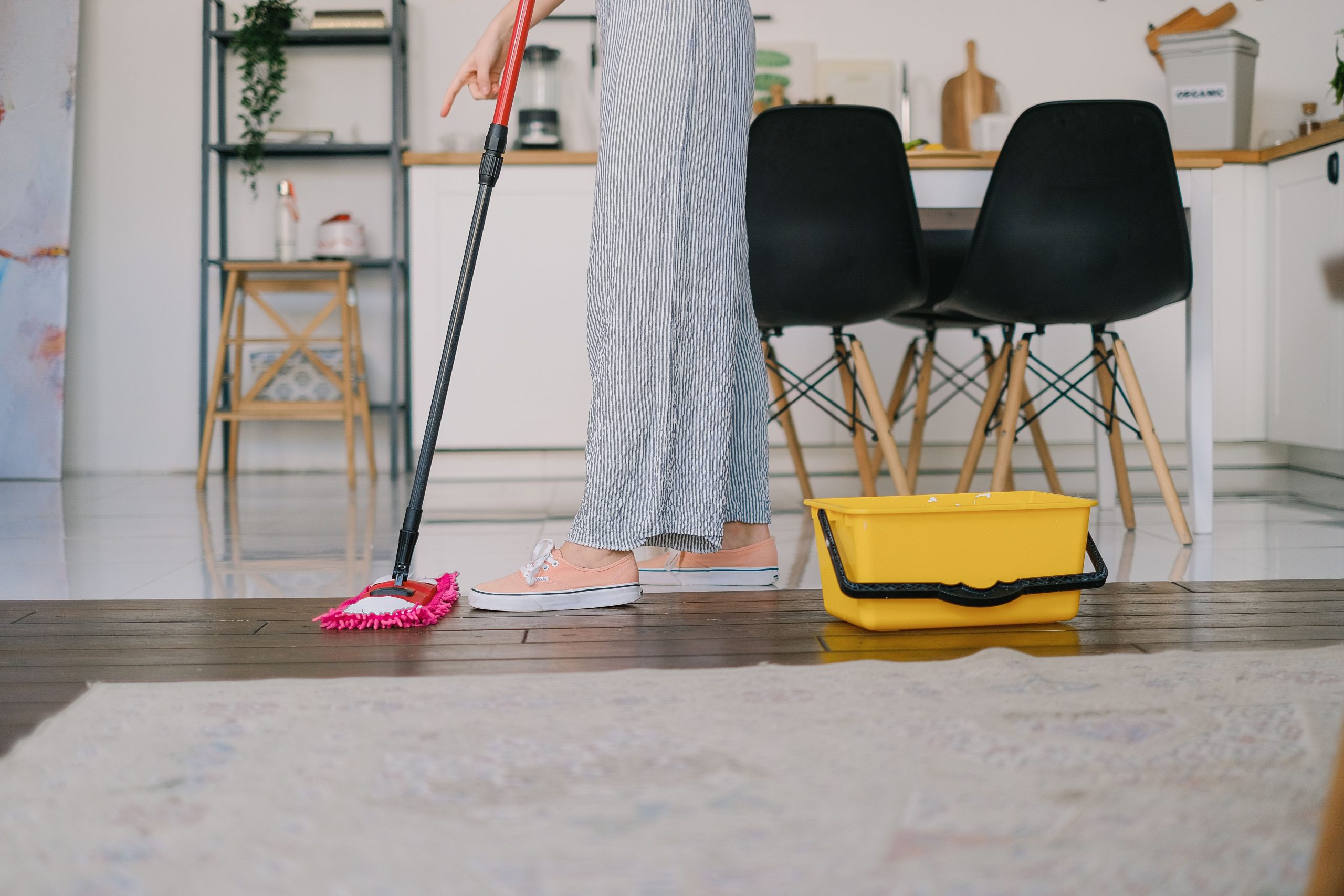 Femme lavant un parquet flottant avec une serpillière