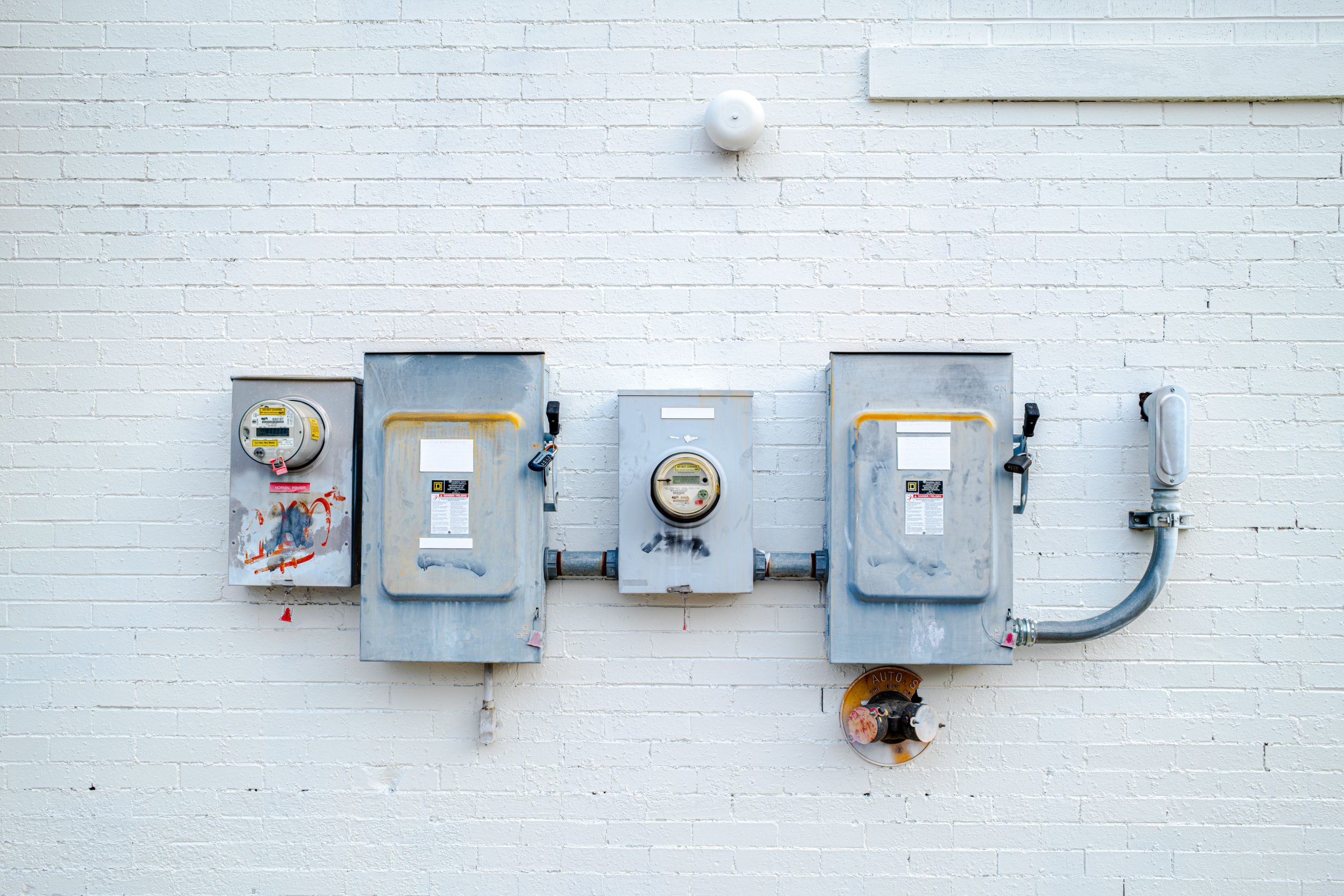 Boitiers electriques et compteurs sur mur blanc