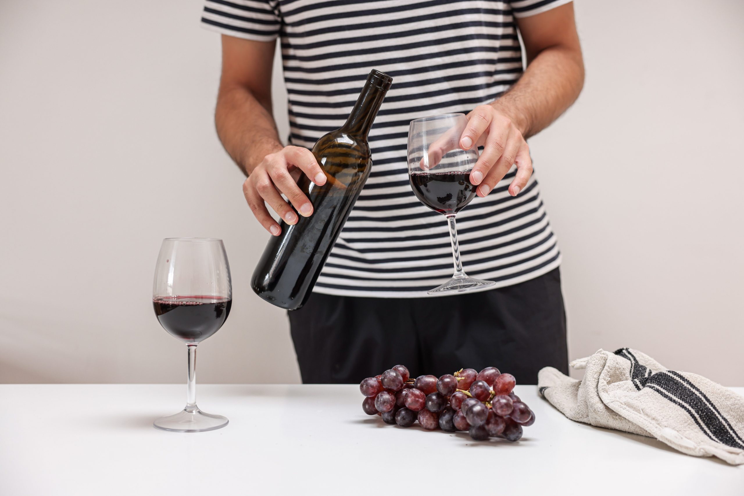 Verre de vin rouge versé avec raisins